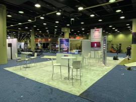 RENTAL: RE-9049 Island Design with Direct Print Sintra Graphics, Large Monitor Mount and 55" Monitor, Attached Tower Counter, and Client&acirc;��s Existing Reception Counter.